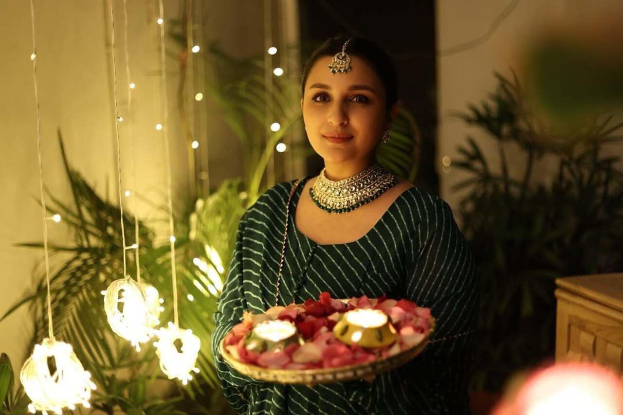 Parineeti picks an elegant leheriya outfit for her previous Diwali celebration. The actress poses with the diyas in her verandah